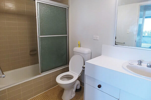 bathroom with old, broken tiles requiring removal by handyman in Bulimba