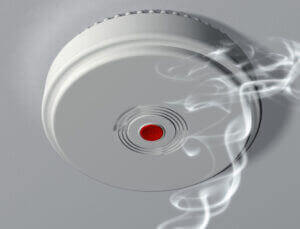 team of qualified electricians installing smoka alarms inside home