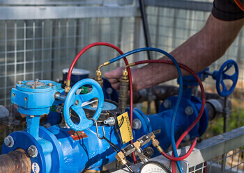 Plumber carrying backflow testing at commercial property