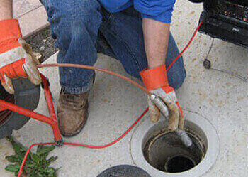 Plumber in Bardon unblocking a blocked pipe