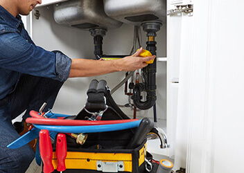 plumber fixing broken pipes inside Brisbane residential home