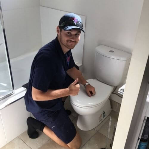 Plumber fixing broken pipe in Brisbane home